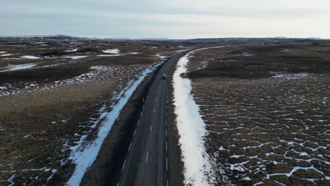 Toma-De-Drone-De-Un-Automóvil-Conduciendo-En-Islandia-Durante-El-Invierno-Con-Nieve2