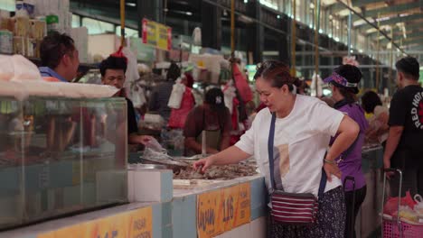 Mujer-Seleccionando-Camarones-En-Un-Puesto-De-Mariscos-En-Un-Mercado-Indonesio