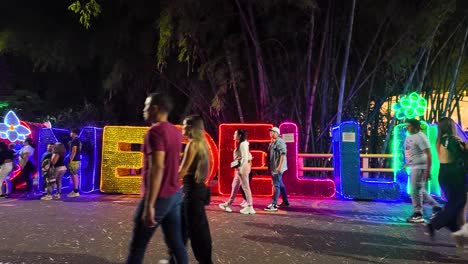Nightlife-in-El-Poblado,-Medellin,-with-people-enjoying-the-illuminated-"Medellin"-sign-in-Provenza