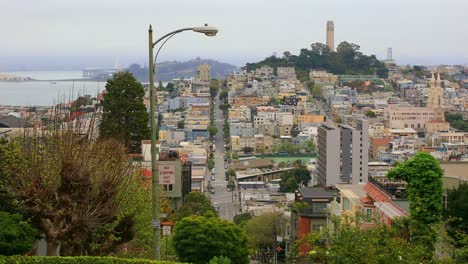 Blick-Auf-Die-Lombard-Street-In-San-Francisco-Mit-Dem-Coit-Tower-In-Der-Ferne,-USA