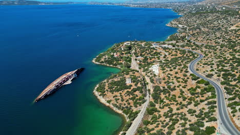 Aerial-view-of-MS-Mediterranean-Sky-reveals-a-rusting-ship-amidst-turquoise-waters-and-coastal-landscape