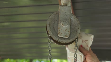 Woman's-Hand-Wiping-The-Pulley-With-Piece-Of-Cloth
