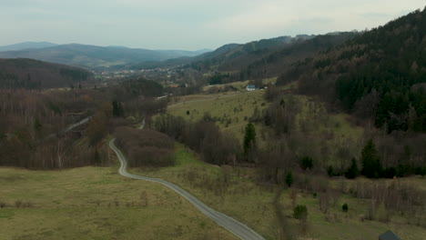 Aerial-view-of-a-valley-with-a-winding-road-and-scattered-houses