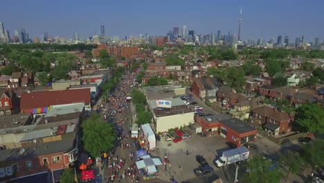 Taste-of-Italy-Along-College-Street-in-Toronto-Overhead-with-Cityscape-Views-from-a-Drone-Dolly-Shot,-Canada