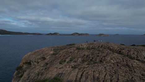 Grupo-De-Personas-Disfrutando-De-La-Brisa-Del-Mar-En-La-Cima-De-La-Colina,-área-De-Cape-Le-Grand,-Australia-Occidental