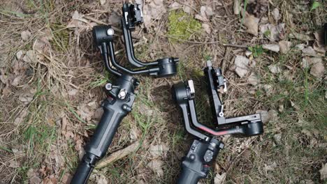 Black-shiny-electronic-gimbal-stabilizers-lay-on-outdoor-ground,-Czechia