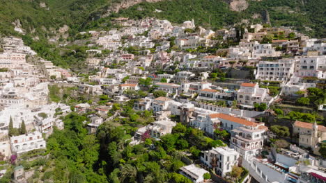 Aerial:-Slow-panning-drone-shot-of-houses-and-hotels-at-Positano-in-Amalfi-coast,-Italy