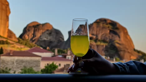 Glass-of-drink-with-scenic-mountain-blurred-background-and-clear-sky