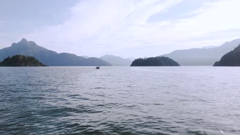 The-tranquil-water-surface-of-Howe-Sound-in-Squamish,-BC,-Canada,-with-Anvil-Island-in-the-background