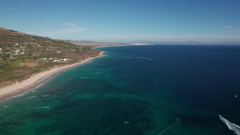 Panorama-Luftaufnahme-Von-Kitesurfern-Beim-Üben-Und-Spaß-Haben-Und-Der-Landschaft-Am-Strand-Von-Tarifa,-Cadiz,-Spanien