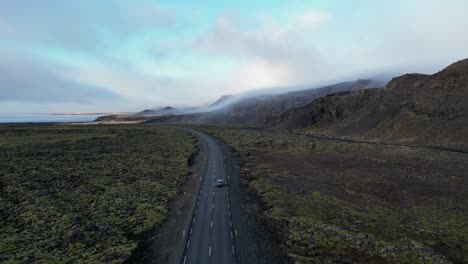 Drone-shot-of-car-driving-in-Iceland-during-winter-on-moss-field4
