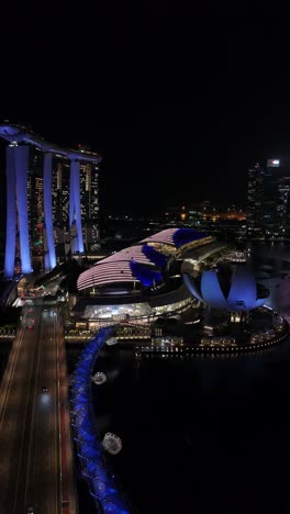 Night-Aerial-View-of-Marina-Bay-Sands-and-Helix-Bridge-in-Singapore,-vertical