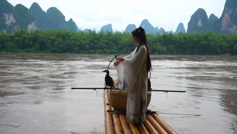 Hanfu-Mädchen-Posiert-Auf-Bambusfloß-Mit-Kormoran-Auf-Dem-Li-Fluss