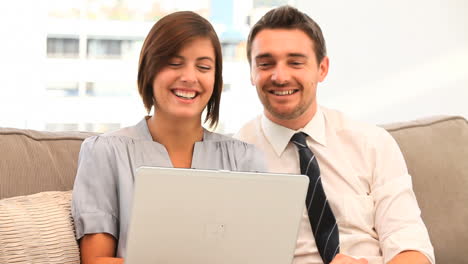 Young-couple-using-a-laptop-on-the-sofa