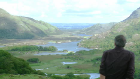 Young-man-sitting-on-the-top-of-a-mountain-