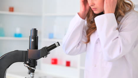 Young-woman-looking-through-a-microscope-