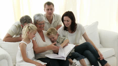 Familia-Feliz-Sentada-En-El-Sofá-Mirando-Un-álbum-De-Fotos-En-Casa