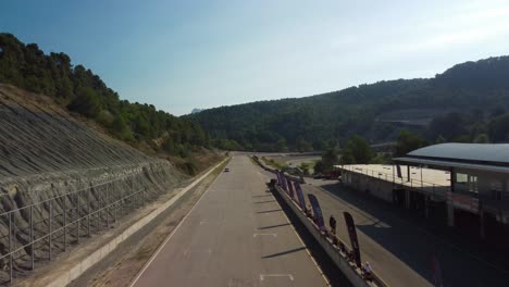 The-castelloli-speed-circuit-in-barcelona-on-a-sunny-day-with-surrounding-hills,-aerial-view