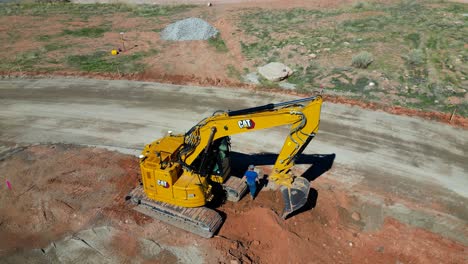 Aerial-Drone-Track-Man-Walking-toward-Excavator