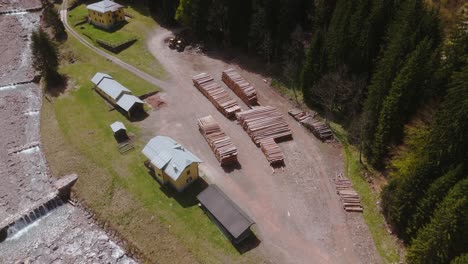 Ein-Sägewerk-In-Einem-Waldgebiet-Mit-Stapeln-Von-Geschnittenen-Baumstämmen-Und-Sichtbaren-Gebäuden,-Luftaufnahme