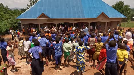 Schüler-Feiern-Gemeinsam-Auf-Dem-Schulhof-Unter-Einem-Sonnigen-Himmel-In-Uganda-Und-Begrüßen-Australische-Besucher