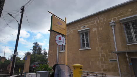 Una-Oficina-De-Correos-En-Nicosia,-Chipre,-Con-Un-Diseño-Arquitectónico-Tradicional,-Con-Carteles-Y-Logotipos-De-Servicios-Postales,-Capturados-En-Cámara-Lenta