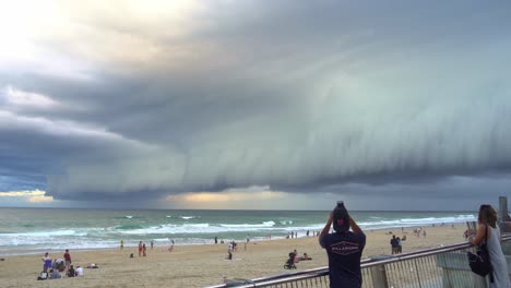 Personas-Reunidas-En-Surfers-Paradise-Beach,-Gold-Coast,-Observando-Una-Dramática-Escena-Apocalíptica-Que-Se-Desarrolla-En-El-Cielo,-Caracterizada-Por-Gruesas-Capas-De-Siniestras-Nubes-Que-Se-Extienden-Por-El-Horizonte.