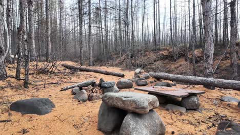 Stone-fire-pit-and-old-camp-in-the-autumn-forest