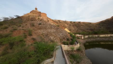 Vista-Panorámica-Aérea-Del-Lago-Sagar-En-La-Ciudad-De-Amer-En-Jaipur,-India,-Destino-De-Viajes-De-Vacaciones-En-Rajasthan,-Drones-Fpv-Volando-Sobre-Las-Paredes-Y-El-Modelo