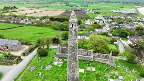 Irland:-Epische-Orte,-Drohnen-Nahaufnahme,-Die-Den-Runden-Turm-Und-Die-Kathedrale-Von-Ardmore-Umkreist,-Mit-Dem-Küstendorf-Ardmore-Im-Hintergrund-In-Waterford