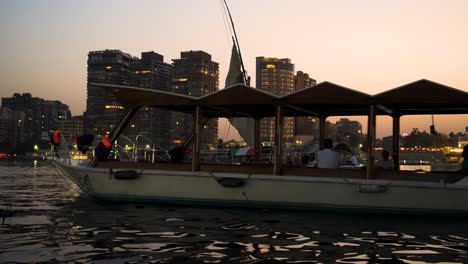 Felucca-and-other-boats-on-the-Nile-River-in-Cairo,-Egypt-at-dusk