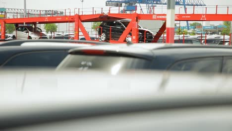 Blurred-cars-at-a-dealership-with-distinct-DB-Schenker-red-structures-in-the-background