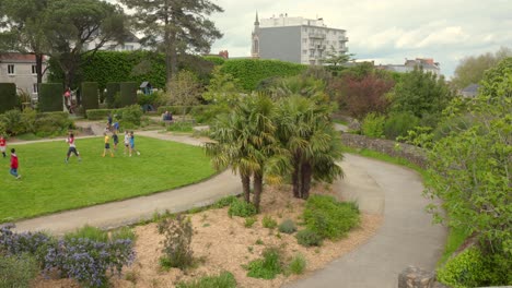 Profile-view-of-kids-playing-and-enjoying-in-Square-Maurice-Schwob-Park-during-daytime-in-Nantes,-France