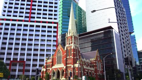 Tilt-up-shot-capturing-the-exterior-details-of-heritage-listed-Victorian-Gothic-Revival-architecture,-Albert-street-uniting-church-against-corporate-office-blocks
