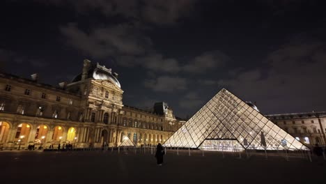 Louvre-Museum-with-glass-pyramid-at-night,-Paris-in-France