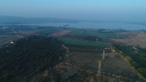 La-Cámara-Del-Dron-Se-Mueve-Hacia-Atrás,-Donde-Hay-Grandes-Parcelas-Para-Fiestas,-Viviendas-Y-También-Muchos-árboles.