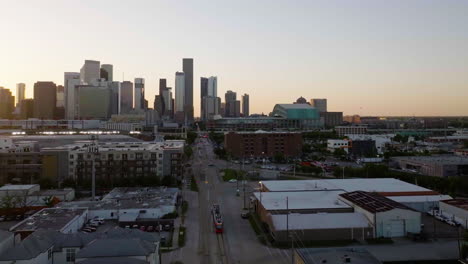 Tranvía-Ligero-Acercándose-Al-Horizonte-De-Houston,-Mañana-Soleada---Disparo-De-Drones