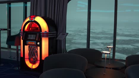 Jukebox-and-Chair-by-Windows-of-Cruise-Ship-Sailing-By-Broken-Pieces-of-Ice-in-Cold-Arctic-Sea