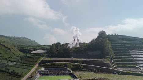 Geothermal-power-plant-emitting-steam-in-mystic-landscape-of-Dieng-Plateau,-Indonesia