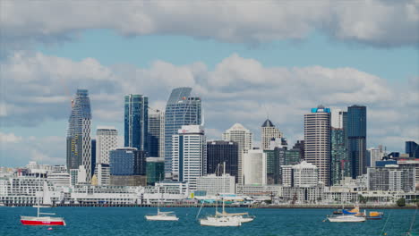 Varios-Barcos-Y-Yates-Amarrados-En-El-Puerto-De-Auckland,-Con-El-CDB-Al-Fondo,-Nueva-Zelanda