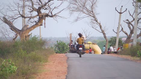 Indische-Dorfbewohner-Mit-Motorrad-Und-Traktor-Auf-Einer-Wunderschönen-Abgelegenen-Dorfstraße-In-Rajasthan,-Indien