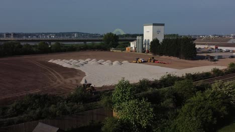 Bulldozer-working-on-sunlit-morning-construction-site-aerial-view-laying-foundation-stone-on-new-housing-estate