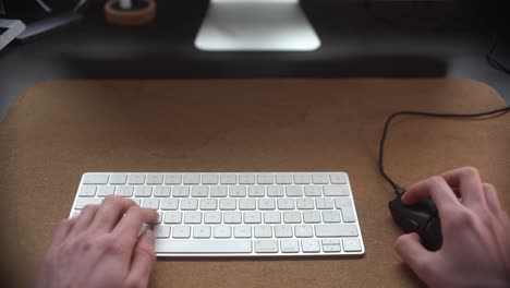 Man-typing-on-his-keyboard-and-using-his-mouse