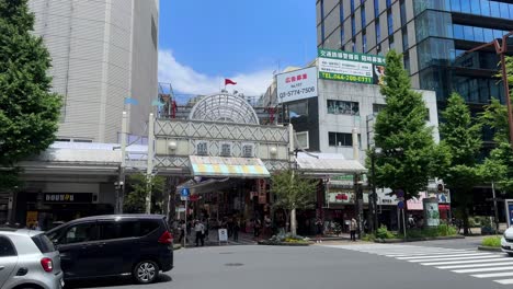 Busy-street-scene-in-Tokyo-with-cars-and-pedestrians-on-a-sunny-day