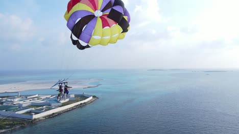 Paar-Im-Inselurlaub-Macht-Selfie-Beim-Parasailing-über-Dem-Himmelblauen-Meer,-Drohne-Folgt