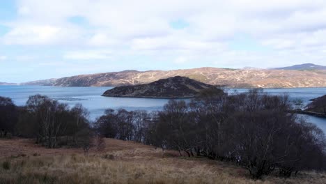 Scenic-panoramic-view-of-Loch-a'-Chàirn-Bhàin-with-water-and-mountainous-landscape-in-Assynt-district-of-Sutherland,-highlands-of-Scotland-UK