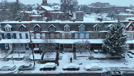 Snow-blankets-historic-row-houses-under-a-gray-sky,-captured-by-a-drone-in-the-USA