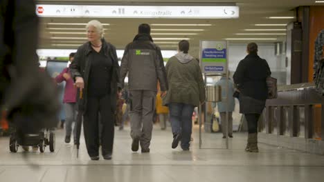 Crowded-subway-station-scene-with-diverse-commuters-walking-and-carrying-shopping-bags,-indoor,-daytime