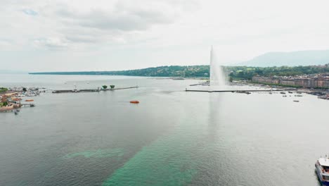 Beautiful-aerial-of-Jet-d'Eau-de-Genève,-the-large-fountain-located-in-the-lake-at-the-skyline-of-Geneva,-Switzerland