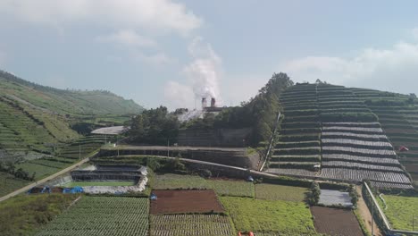 Geothermal-power-plant-emitting-steam-in-mystic-landscape-of-Dieng-Plateau,-Indonesia